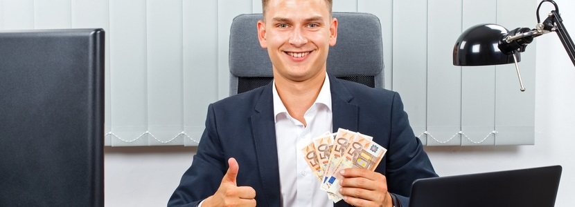 Jeune entrepreneur tenant des billets d'euros à son bureau