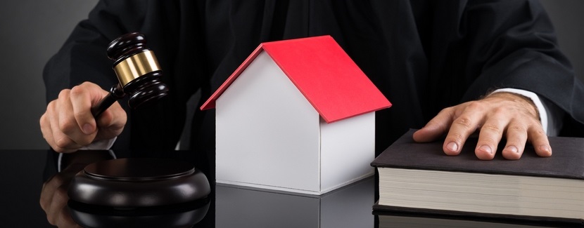  Un juge à son bureau et une maison en miniature