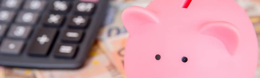 Une tirelire sur des billets euros avec une calculatrice