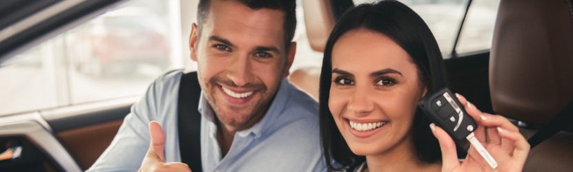 Jeune couple montre la clé de leur nouvelle voiture