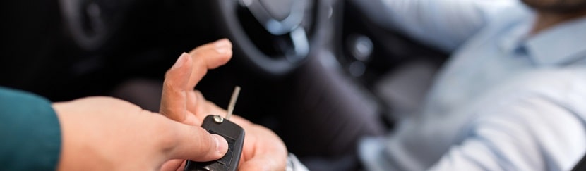 un homme en voiture recevant sa clé de voiture